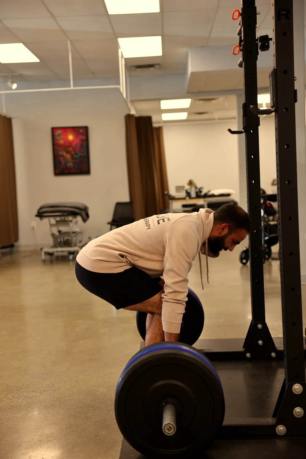Person setting up for a deadlift with a loaded barbell.